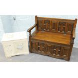 An Old Charm monk's type bench, with lift up seat, shaped arms and panelled back and front, 97cm