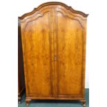 A figured walnut wardrobe, with a domed top, on short shell carved cabriole legs, 125cm wide