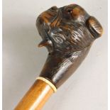 An early 20thC walking stick, the handle carved in the form of a mastiff type dog, with glass eyes