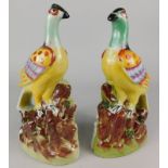 A pair of modern Staffordshire style porcelain models of pheasants, on a stylised rock base, late