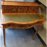 A yew bonheur du jour, with six drawers, the serpentine fronted top with leather inset above two