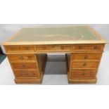 A late 19th/early 20thC oak partner's type desk, the rectangular top with a green leather insert and