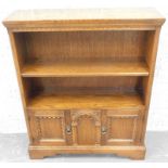 An Old Charm style type oak bookcase, with two panel doors, on bracket feet, 84cm wide