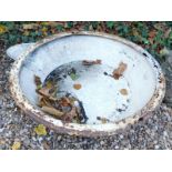 A large circular metal drinking trough