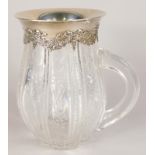 A Tiffany cut glass jug, decorated with bands of flowers, leaves, etc., with silver mount cast