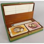 An early 20thC leather bridge box, containing playing cards, scorers etc.