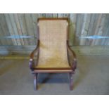 A cane seated chair on mahogany frame with scroll arms