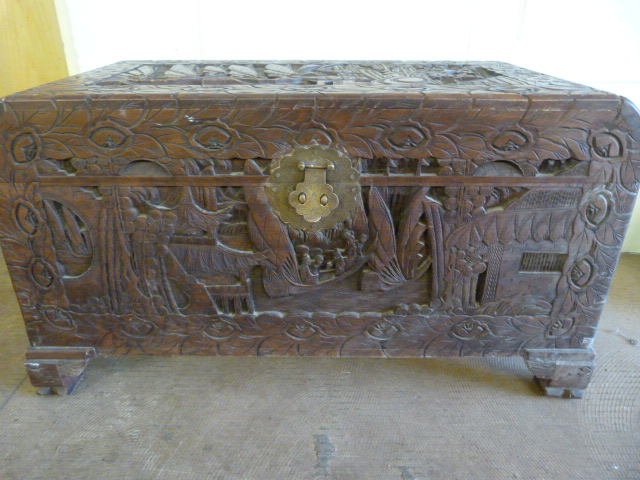 A Chinese Camphorwood chest with heavily carved inset decoration