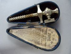 A cased champagne tap. Length 95 mm (original lining displays "Directions for Use")