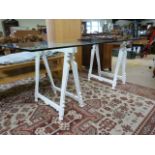 A Large modern glass table on trestle legs