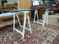 A Large modern glass table on trestle legs