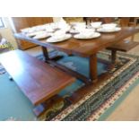 A Large oak planked dining room table with two bench seats