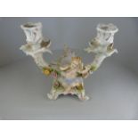 A Sitzendorf floral encrusted candle holder decorated with Cherub to front