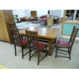 An oak farmhouse dining room table with panelled top and four chairs