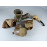 Three various sized matching African pottery pipe bowls and two wooden pipes one tribal with remains