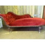 A Red upholstered Chaise Lounge on original castors