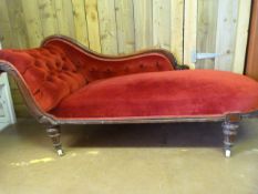 A Red upholstered Chaise Lounge on original castors