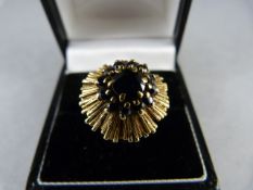 A 9ct yellow Gold contemporary 70's style ring set with 12 small blue stones circling an approx 6.