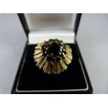 A 9ct yellow Gold contemporary 70's style ring set with 12 small blue stones circling an approx 6.