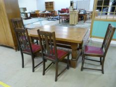 An oak farmhouse dining room table with panelled top and four chairs