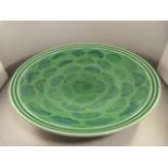 A Poole Pottery charger with green Iridescent glaze by Nikki Massarella