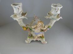 A Sitzendorf floral encrusted candle holder decorated with Cherub to front