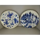 A pair of Japanese blue & white plates/chargers - 1 depicting Japanese artefacts and the other a
