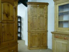 An antique pine corner cupboard