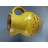 Fremington pottery jug by Edwin Beer Fishley with yellow glaze and the inscription ‘If you cant be