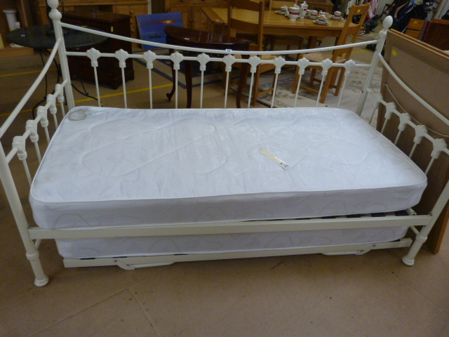 A White metal framed Day Bed with mattress under