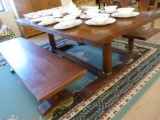 A Large oak planked dining room table with two bench seats