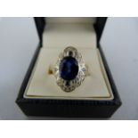 A Silver Ring set with an oval 10.10mmx8.5mm and four small Sapphire blue CZ stones with 28 small