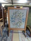 An oak Art Deco embroidered fire screen and a wooden stool