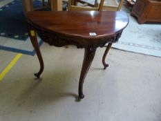 A reproduction mahogany half moon table on Concave legs