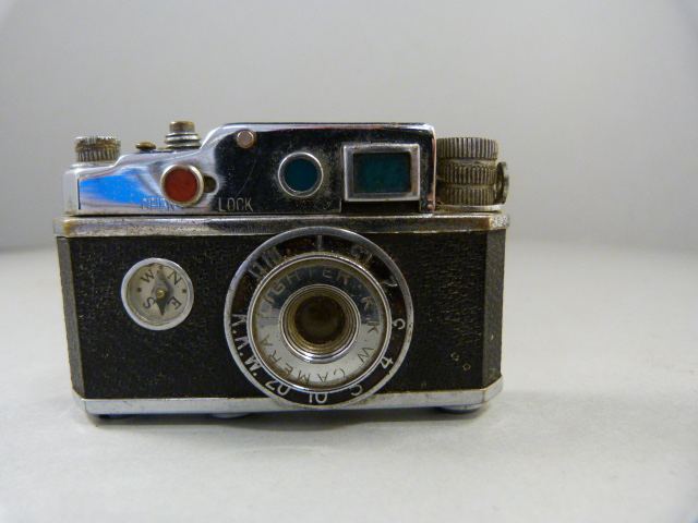 A Novelty lighter in the form of a camera - with compass and the spark creating the 'Flash'