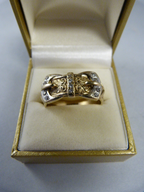 9ct gold gents double buckle ring set with 12 small white stones (possibly white sapphires) 10.4 gms