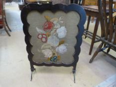 An Art Nouveau style firescreen with needlework decoration