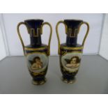 A Pair of Berlin Two handled Urns with hand-painted foliate Gilt decoration