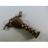 Novelty pipe tamper in the form of a hand holding a pipe