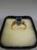 9ct gold ring with oval Topaz (possibly heat treated) and diamond cluster. Three accent diamonds