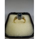 9ct gold ring with oval Topaz (possibly heat treated) and diamond cluster. Three accent diamonds