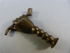 Novelty pipe tamper in the form of a hand holding a pipe