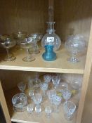Quantity of Edwardian cut glass, two decanters and blue rimmed small vase over two shelves