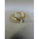 9ct gold ring set with possibly aqua marine oval in shape and with diamond to each shoulder