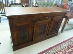 An oak sideboard with two cupboards and three drawers over