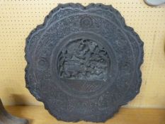 A round heavily carved Indian table top