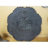 A round heavily carved Indian table top