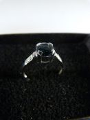 9ct Solitaire style white gold ring set with round possibly Tourmaline with two accent diamonds to