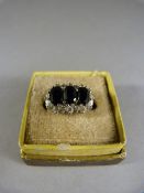 9ct ring set with three dark Sapphires and surrounded by Cubic Zirconia's