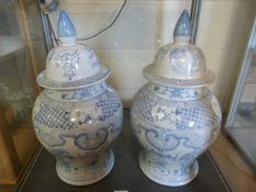 A pair of Chinese Blue and White Baluster vases with lids. Scenes depicting dragons and birds.
